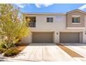 Two-story townhome featuring attached garages and desert landscaping at 2495 Sunflower Days Ave # 2052, North Las Vegas, NV 89031