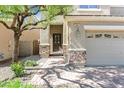 Inviting front entrance featuring a two-car garage, stone accents, and a brick walkway at 2864 Kinknockie Way, Henderson, NV 89044