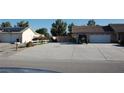 Spacious driveway leading to a two-car garage with an adjacent low-maintenance landscaped area at 30 Diamond Bar Rd, Pahrump, NV 89048
