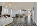Open living room with wood-look tile flooring, modern lighting, and outdoor access at 3096 Beaux Art Ave, Henderson, NV 89044