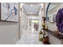 Hallway view with white tile flooring and decorations on a console table at 3929 Reyes Ave, Las Vegas, NV 89141