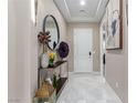 Bright entryway with white tile flooring, a decorative console table, and a round mirror at 3929 Reyes Ave, Las Vegas, NV 89141