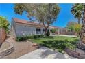 A lush backyard featuring a well-maintained lawn, covered patio, and privacy landscaping at 4197 Bottiglia Ave, Las Vegas, NV 89141