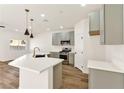 Modern kitchen with an island, stainless steel appliances, gray cabinets, and a gold faucet at 4779 Straight Flush Dr # 103, Las Vegas, NV 89122