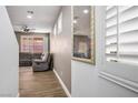 This open-plan room features wood floors, a comfortable gray sofa, and shutters for privacy at 4786 Castel Martini Ct, Las Vegas, NV 89147