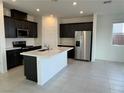 Modern kitchen with stainless steel appliances, a large island, and dark cabinets at 5175 Capucina St # Lot 5, Las Vegas, NV 89122