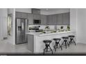 Contemporary kitchen with gray cabinetry, stainless steel appliances, and a stylish breakfast bar at 5773 Crenellated St # Lot 57, Las Vegas, NV 89148