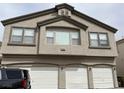 Multi-level townhome with three-car garage and neutral stucco finish at 6462 Saddle Up Ave # 103, Henderson, NV 89011