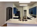 Bright kitchen featuring dark blue cabinetry, white countertops, and stainless steel appliances at 6462 Saddle Up Ave # 103, Henderson, NV 89011