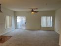 Bright living room with neutral carpet, ceiling fan, and sliding glass door at 6462 Saddle Up Ave # 103, Henderson, NV 89011