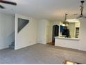 Open-concept living room with neutral carpet, adjacent kitchen, and stairway at 6462 Saddle Up Ave # 103, Henderson, NV 89011
