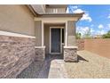 Inviting covered front entry with stone accents and a modern front door at 6783 Pleasant Flower St, Las Vegas, NV 89149