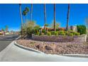 Canyon Ranch Estates entrance featuring brick signage, lush landscaping, and mature palm trees at 7461 Tahoe Basin Dr, Las Vegas, NV 89129