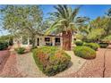 Charming property featuring mature trees, landscaped with lush shrubbery, and a brick-lined garden at 7461 Tahoe Basin Dr, Las Vegas, NV 89129