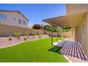 Private backyard with a well-maintained lawn and covered patio for outdoor enjoyment at 7813 Paper Flower Ct, Las Vegas, NV 89128