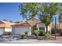 Charming single-story home featuring a terracotta tile roof, two-car garage, and well-maintained landscaping at 8109 Sunset Mill Dr, Las Vegas, NV 89128