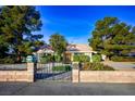 Well-maintained home with mature trees, a gated entrance, and an extended driveway at 8365 S Hauck St, Las Vegas, NV 89139