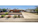 Charming single-story home with an expansive driveway, xeriscaping, and lush landscaping at 929 Center St, Henderson, NV 89015