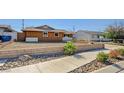 Charming single-story home with an expansive driveway, xeriscaping, and lush landscaping at 929 Center St, Henderson, NV 89015