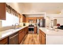 Well-lit kitchen boasts stainless steel appliances, wooden cabinets, and a modern design at 945 Stetson Dr, Henderson, NV 89002
