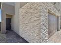 Modern home exterior with stone accents, gray door, and paved walkway at 9714 Harper Edge St, Las Vegas, NV 89143