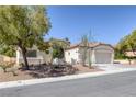 Inviting one-story home showcases desert landscaping, a tiled roof, and an attached garage at 10113 Plomosa Pl, Las Vegas, NV 89134