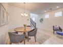 Dining area with a round wooden table, comfortable seating, and a stylish chandelier for elegant dining at 12286 Silvana St, Las Vegas, NV 89141