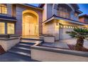 Charming home entrance with a large front door, well-lit, and manicured landscape at 2448 Ram Crossing Way, Henderson, NV 89074