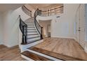 Bright foyer with a grand staircase, elegant chandelier, and sleek wood flooring at 2448 Ram Crossing Way, Henderson, NV 89074