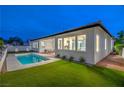 Backyard view featuring a private pool, well-maintained artificial turf, and a covered patio at 3020 Via Venezia, Henderson, NV 89052