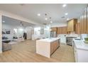 Bright open-concept kitchen with stainless steel appliances, island seating, and an adjacent living area at 3020 Via Venezia, Henderson, NV 89052