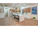 Modern kitchen featuring stainless steel appliances, a waterfall island with seating, and stylish pendant lighting at 3020 Via Venezia, Henderson, NV 89052