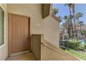 Exterior entryway showcasing a front door with view of pool, fence, and palm trees at 3145 E Flamingo Rd # 2080, Las Vegas, NV 89121