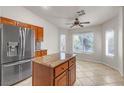 Bright kitchen with stainless steel refrigerator, island, and natural light from the window at 3521 Amish Ave, North Las Vegas, NV 89031