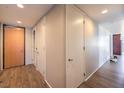 Hallway with wooden floors, white walls, and multiple doors, providing safety and access at 353 E Bonneville Ave # 379, Las Vegas, NV 89101