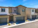 Exterior view showcasing attached townhomes with garages and tidy landscaping at 4229 Venus Falls Ave, North Las Vegas, NV 89084