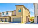 Street view featuring well-maintained townhomes with two-car garages and sidewalks at 4229 Venus Falls Ave, North Las Vegas, NV 89084