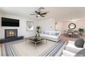 Bright living room with fireplace, ceiling fan, neutral color palette, and adjacent dining area at 4301 Fortune Ave, Las Vegas, NV 89107