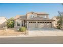 Two-story home featuring a two-car garage and desert landscaping at 5133 Burr Oak Dr, Las Vegas, NV 89130