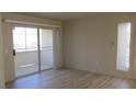 Bright living room featuring sliding glass doors and wood-look flooring at 5710 E Tropicana Ave # 1114, Las Vegas, NV 89122
