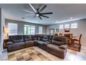 Spacious living room featuring a large sectional couch, fan, and dining room view at 5854 Olivine Falls Ave, Las Vegas, NV 89130