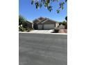 Inviting single-story home with stucco exterior, a two-car garage, and manicured desert landscaping at 6712 Tattler Dr, North Las Vegas, NV 89084