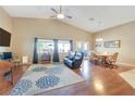 Spacious living room with vaulted ceilings, hardwood floors, a ceiling fan, and natural light from large windows at 6712 Tattler Dr, North Las Vegas, NV 89084