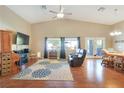 Bright living room features vaulted ceilings, hardwood floors, a ceiling fan, and furniture at 6712 Tattler Dr, North Las Vegas, NV 89084