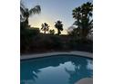 Inviting backyard pool surrounded by lush landscaping, perfect for relaxation and entertaining at 6712 Tattler Dr, North Las Vegas, NV 89084