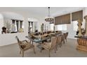Formal dining room with a large table set for a dinner party under a chandelier at 6739 Quapaw St, Las Vegas, NV 89149