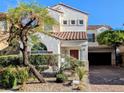 Charming two-story stucco home featuring a red tile roof, desert landscaping, and a brick driveway at 8159 Base Camp Ave, Las Vegas, NV 89178