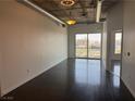 Bright living room features exposed ductwork, polished concrete floors, and city views at 900 Las Vegas Blvd # 1003, Las Vegas, NV 89101
