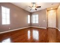 Bright and airy living room with hardwood floors, large windows, and a ceiling fan at 9025 Rusty Rifle Ave, Las Vegas, NV 89143