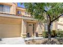 Inviting two-story home with a tan exterior, a well-manicured lawn, and an attached garage at 9428 Sierra Summit Ave, Las Vegas, NV 89134